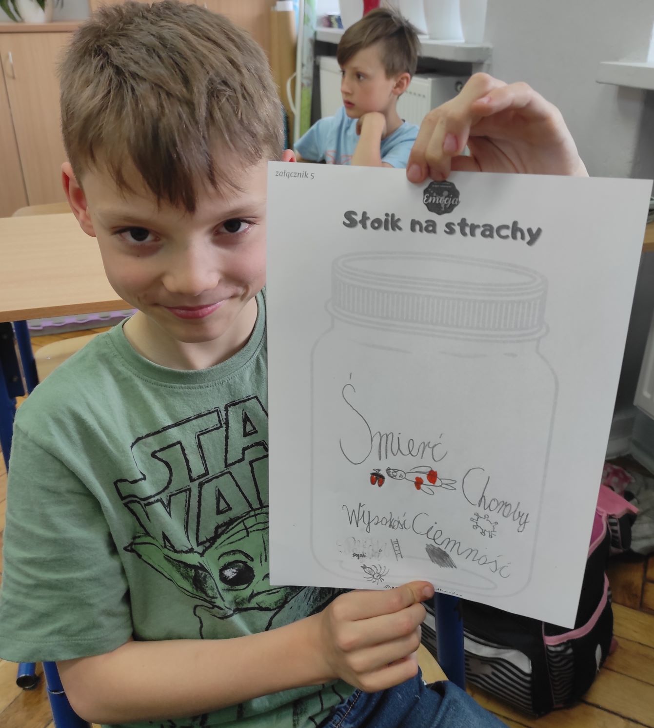 chłopiec trzyma rysunek